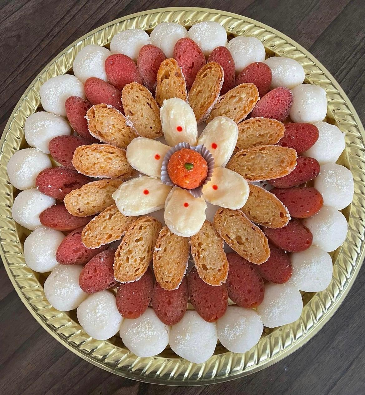 Red, white and golden sweets arranged in a floral pattern