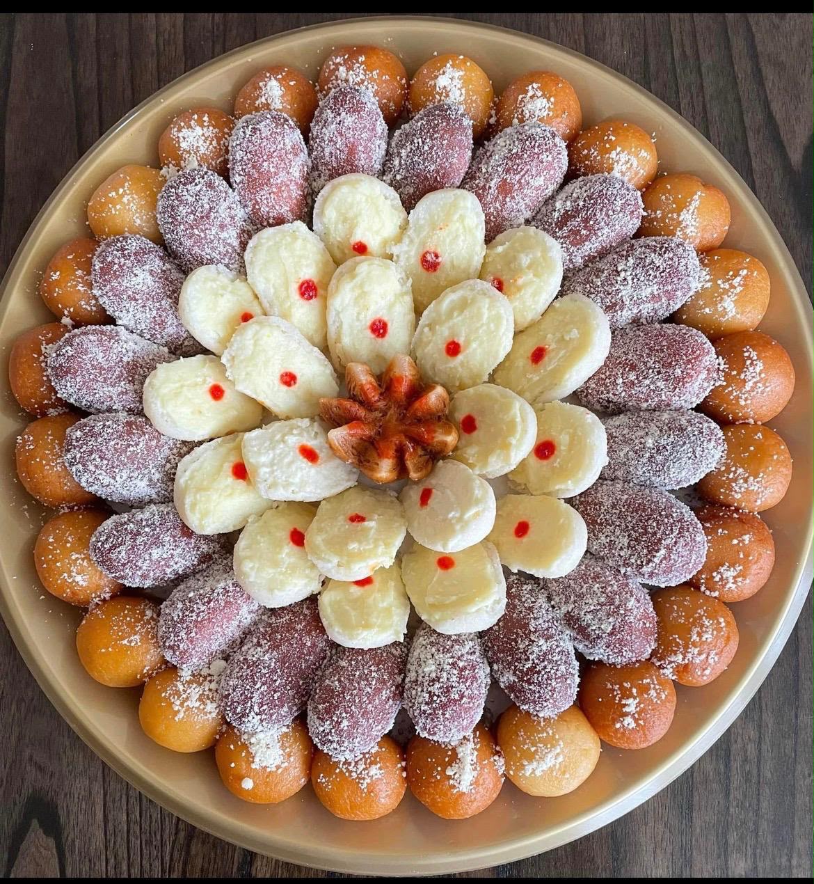 Golden bondia and sandesh platter with floral arrangement